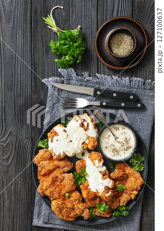 Deep fried Southern chicken thighs with milk gravy 127100637