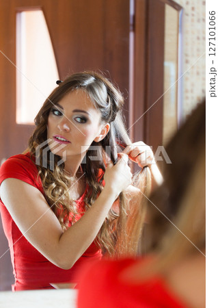 Attractive woman making hairstyle. 127101066