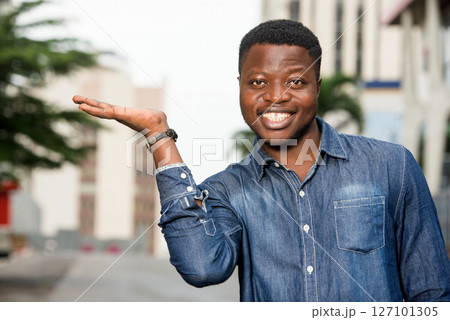 happy man in shirt gesturing a welcome sign 127101305