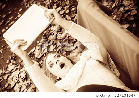 Girl sitting on bench with tablet. 127101647