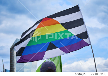 Pride Flag Against Sky. A pride flag with black and white stripes and rainbow triangle 127101949