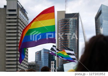 Pride Flags in Cityscape. Colorful pride flags waving against a modern urban skyline 127101952