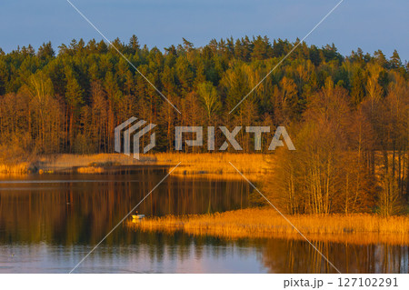 A Serene Lake Reflection with Vibrant and Colorful sunset colors A Serene Lake Reflection with Vibrant and Colorful sunset colors 127102291