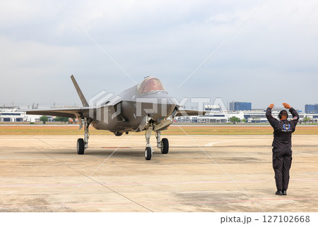 Airbase marshalling supervisor at the airbase apron on duty to take F35 taxiing to the parking place. 127102668