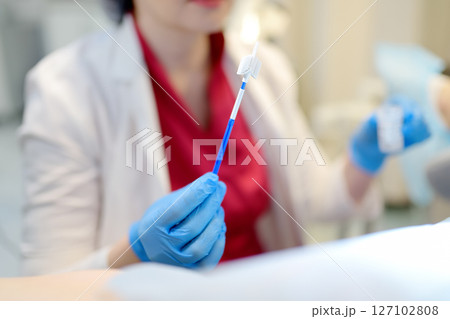 Gynecologist examines a patient takes a smear from a woman cervix. Close up view of doctor hands with gynecological cytobrush. Diagnosis of female viral and infection diseases. Gynecologist examines a patient takes a smear from a woman cervix. Close up view of doctor hands with gynecological cytobrush. Diagnosis of female viral and infection diseases. 127102808