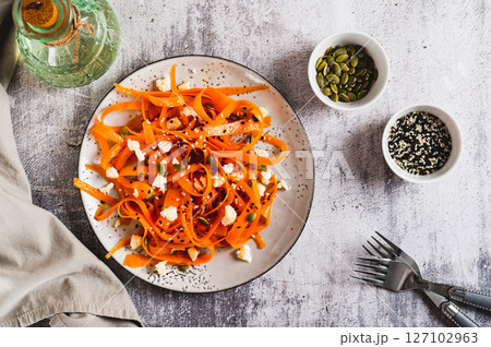 Spicy carrot, ricotta and pumpkin seed salad on a plate on a table top view Spicy carrot, ricotta and pumpkin seed salad on a plate on a table top view 127102963