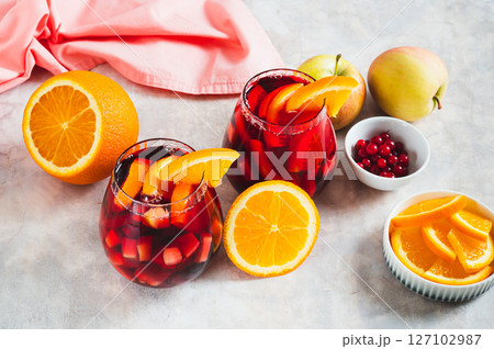 Sangria cocktail with red wine and fruits in glasses on table Sangria cocktail with red wine and fruits in glasses on table 127102987
