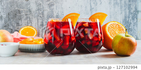 Refreshing summer sangria cocktail with fruits and berries in glasses on the table web banner 127102994