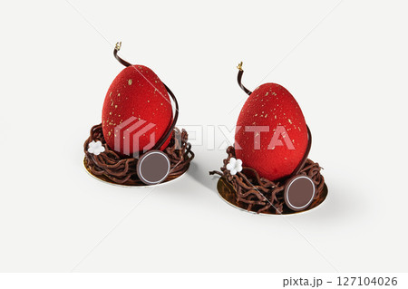 Two red easter eggs sitting in chocolate nests decorated with gold and flowers 127104026