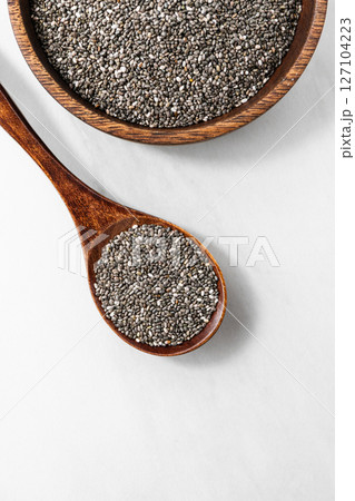 Top view of chia seeds in a wooden bowl with a spoon. Healthy superfood concept Top view of chia seeds in a wooden bowl with a spoon. Healthy superfood concept 127104223