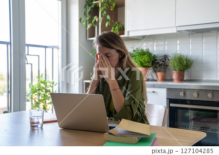 Unhappy worried woman with fatigue from intense remote work laptop, tired have professional burnout. 127104285