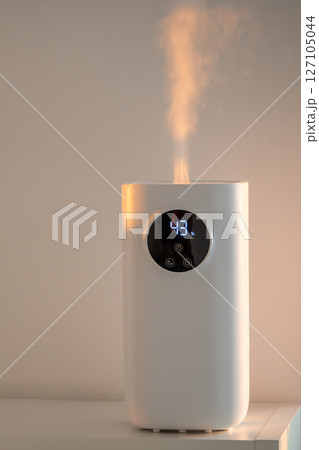 Modern humidifier at home, moistens dry air in living room. Apartment with moisturizer. Modern humidifier at home, moistens dry air in living room. Apartment with moisturizer. 127105044