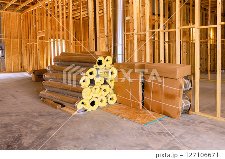Insulation materials are neatly stacked on concrete floor within construction site undergoing renovation work. Insulation materials are neatly stacked on concrete floor within construction site undergoing renovation work. 127106671