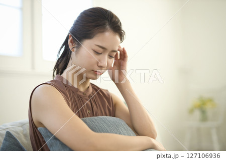 ソファに座る体調不良の20代女性 ソファに座る体調不良の20代女性 127106936