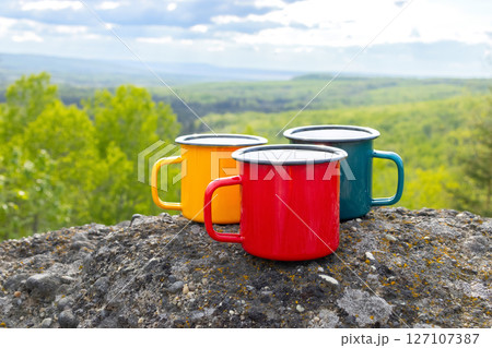 Colorful camping Cups on Rocks Overlooking Valley Colorful camping Cups on Rocks Overlooking Valley 127107387