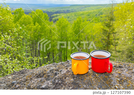 Colorful camping Cups on Rocks Overlooking Valley 127107390