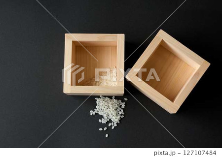 黒背景に少しのコメが入った升とこぼれたコメ 黒背景に少しのコメが入った升とこぼれたコメ 127107484