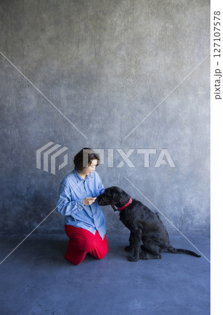 黒い犬と遊ぶ女性 127107578