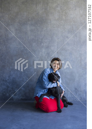 黒い犬と遊ぶ女性 127107582