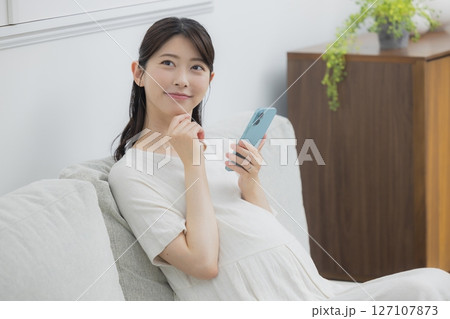 スマホを見る妊婦 127107873