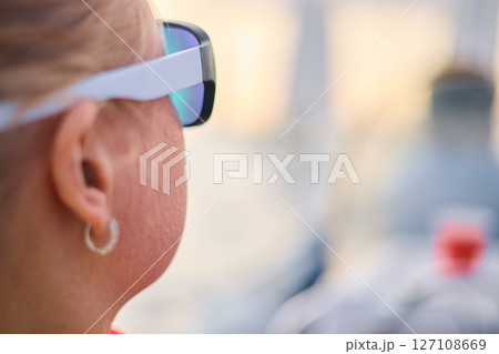 A girl looks at the regatta through sunglasses 127108669