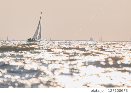 Sailing regatta in the Gulf of Finland at sunset, sailing yacht competing in a race, splashing water from under the boat, teamwork, board the boat 127108678