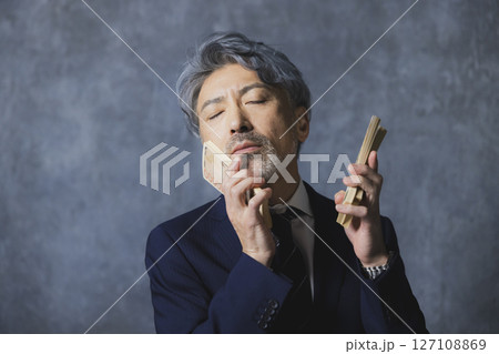 札束を持つ笑顔のシニアビジネスマン 札束を持つ笑顔のシニアビジネスマン 127108869