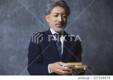 札束を持つ笑顔のシニアビジネスマン 127108878