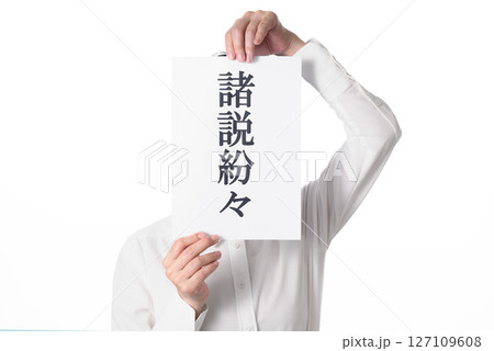 諸説紛々と書かれた紙を持つ人物 127109608