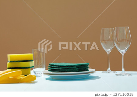 Cleaned plates and wine glasses and forks, combined with a sponge and rubber gloves, illustrate the cleaning power of household dish washing detergents. Cleaned plates and wine glasses and forks, combined with a sponge and rubber gloves, illustrate the cleaning power of household dish washing detergents. 127110019