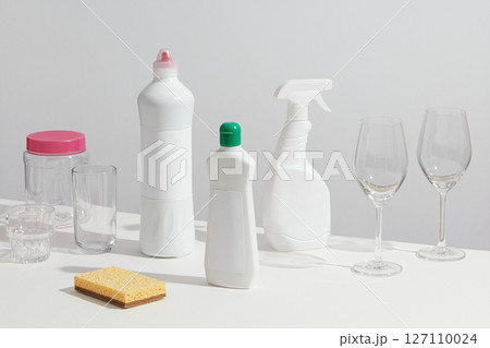 Group of cleaning bottles, brushes, and dish soap gathered with wine glasses, illustrating a kitchen cleanup scene. Mockup for cleansing products,cleaner concept Group of cleaning bottles, brushes, and dish soap gathered with wine glasses, illustrating a kitchen cleanup scene. Mockup for cleansing products,cleaner concept 127110024