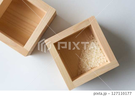 白背景に2つの升と少しのコメ 127110177