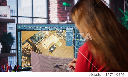Graphic artist uses architectural software and blueprints to create 3D render of a home interior. Program allows to configure furniture and other design elements for a virtual layout. Camera B. Graphic artist uses architectural software and blueprints to create 3D render of a home interior. Program allows to configure furniture and other design elements for a virtual layout. Camera B. 127110301
