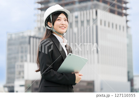 スーツにヘルメット被ってタブレットをもつ若い女性 施工管理者 現場監督 土木女子(ドボジョ) スーツにヘルメット被ってタブレットをもつ若い女性 施工管理者 現場監督 土木女子(ドボジョ) 127110355