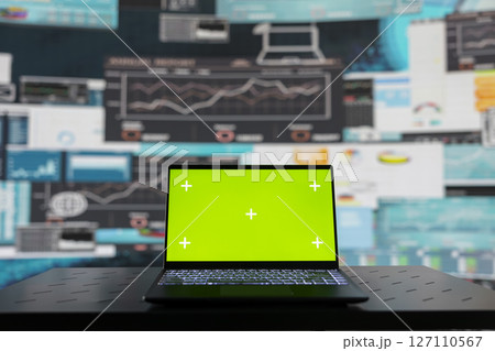 Laptop with a copy space display on empty desk next to performance metrics, showcasing finance graphs and strategy tools to guide a new investment and decision making. Business growth. 127110567
