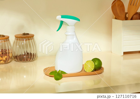 A spray bottle and fresh lemon placed on a cutting board in a warm kitchen space highlight the natural ingredients in a daily cleaning routine. Lime-scented or lime-infused products A spray bottle and fresh lemon placed on a cutting board in a warm kitchen space highlight the natural ingredients in a daily cleaning routine. Lime-scented or lime-infused products 127110716