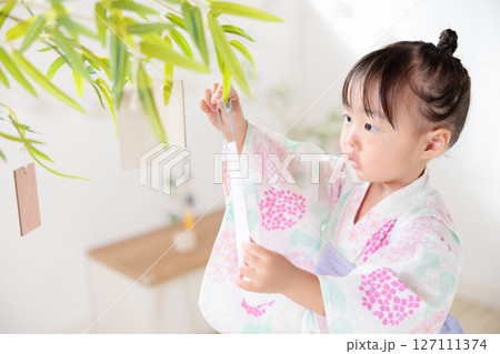 七夕 笹の葉に短冊を飾り付ける2歳の女の子 願い事 笹飾り 願いごと 一夜飾り 七夕 笹の葉に短冊を飾り付ける2歳の女の子 願い事 笹飾り 願いごと 一夜飾り 127111374