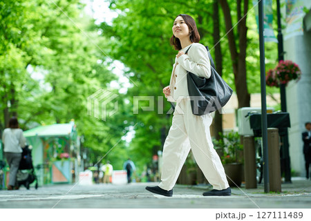 緑のある街並みを歩く女性 緑のある街並みを歩く女性 127111489