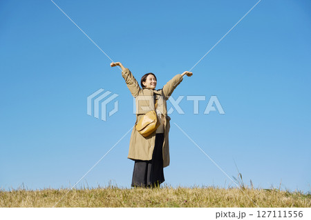 女性　ミドルエイジ　伸び　青空　全身 127111556