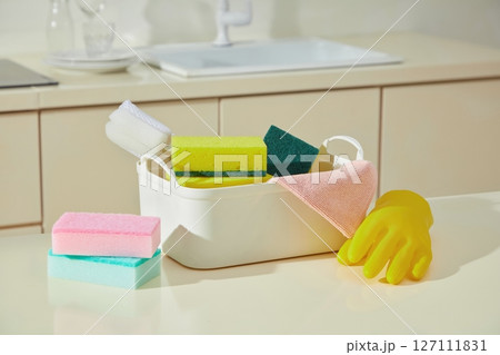 Sponges and cleaning cloths organized near the sink with rubber gloves, expressing cleanliness and the rhythm of household chores. Set of cleaning product Sponges and cleaning cloths organized near the sink with rubber gloves, expressing cleanliness and the rhythm of household chores. Set of cleaning product 127111831