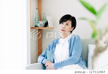リビングで落ち込む中高年女性 リビングで落ち込む中高年女性 127112067