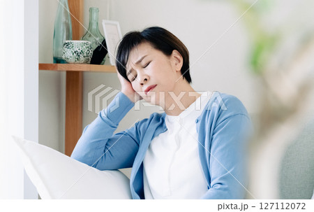 リビングで落ち込む中高年女性 リビングで落ち込む中高年女性 127112072