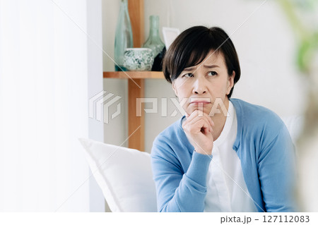 リビングで落ち込む中高年女性 リビングで落ち込む中高年女性 127112083