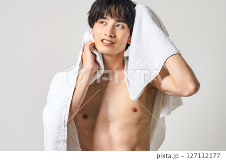 バスタオルで髪の毛を拭く若い男性 127112177