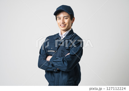 作業服を着て腕組みをする20代の若い男性 作業服を着て腕組みをする20代の若い男性 127112224