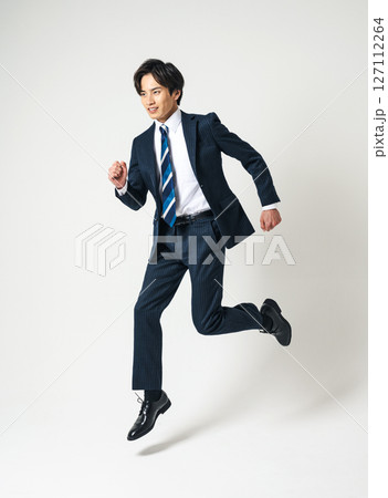 ジャンプするスーツを着た20代の若いビジネスマン ジャンプするスーツを着た20代の若いビジネスマン 127112264