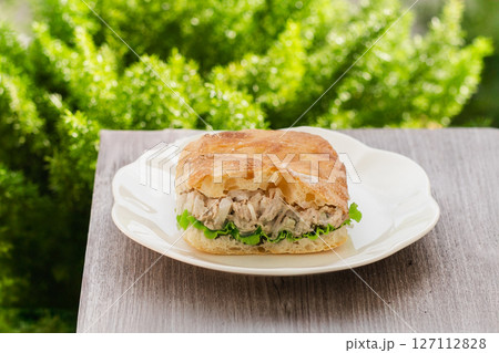 Tuna salad sandwich with lettuce on ciabatta bread on table. 127112828