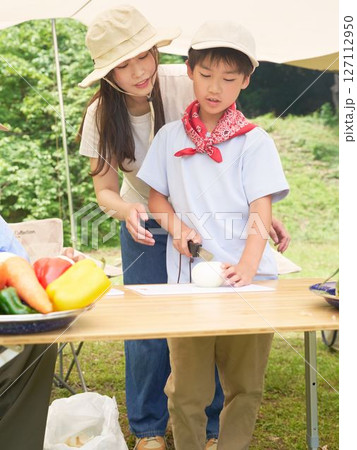 野菜の切り方を学ぶ小学生の男の子 127112950