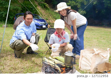 野外調理に挑戦する子供と見守る両親 野外調理に挑戦する子供と見守る両親 127112958