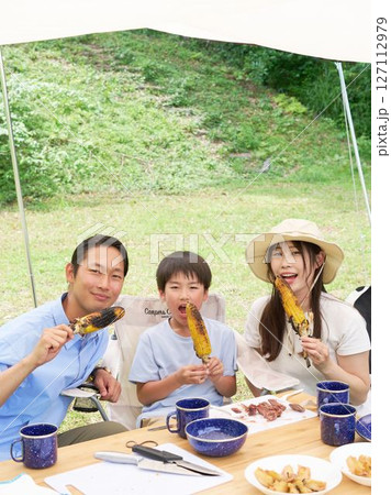 焼きとうもろこしを手に笑顔の家族 焼きとうもろこしを手に笑顔の家族 127112979